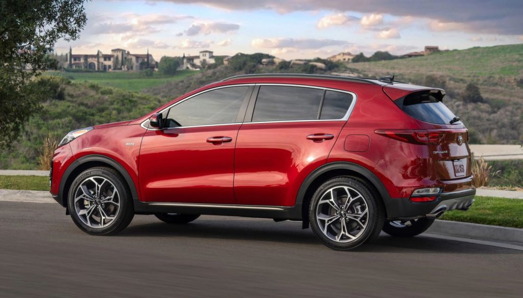 Profile view of a red 2022 Kia Sportage parked on the road. | Kia Dealer in Conway, AR.