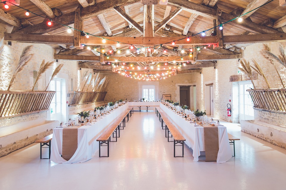 Banquet style tables decorated with a rustic theme for a wedding in a barn style space. | Wedding venues around Conway, AR.