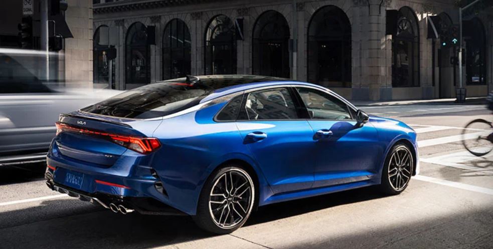 A royal blue 2022 Kia K5 stopped at a stoplight. | Kia dealer in Conway, AR.