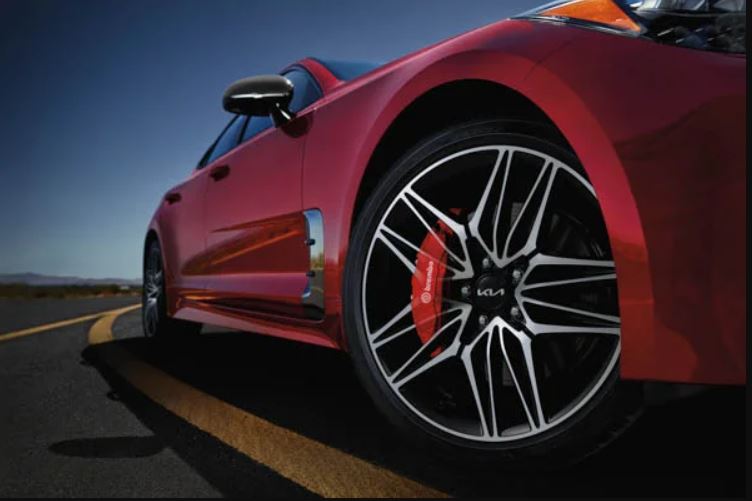 Close view of the front passenger tire of a red 2022 Kia Stinger. | Kia dealer in Conway, AR.