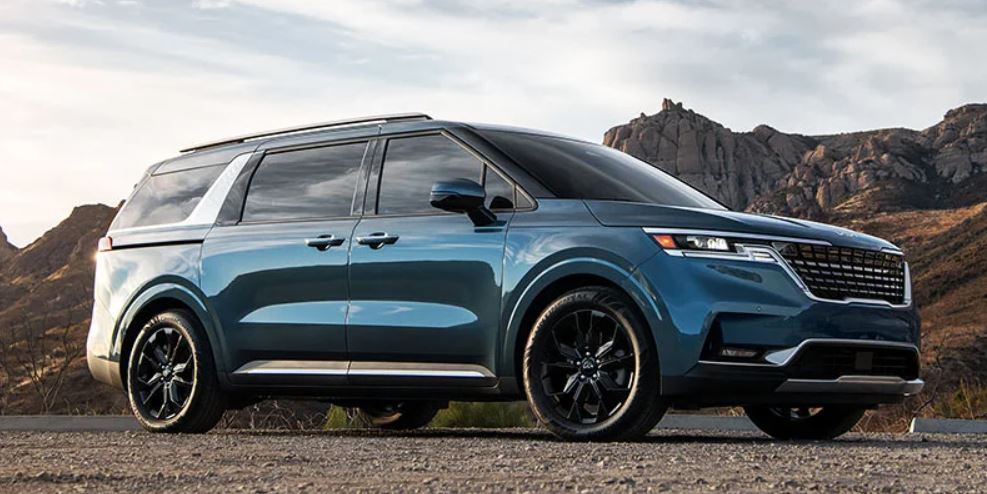 Profile view of a parked, turquoise 2022 Kia Carnival. | Kia dealer in Conway, AR.