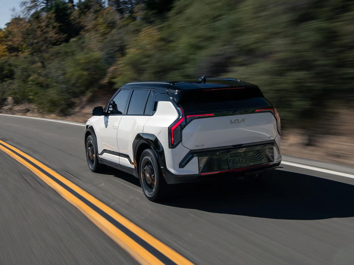 2027 Kia EV3 electric SUV driving on a scenic highway with advanced technology and modern design